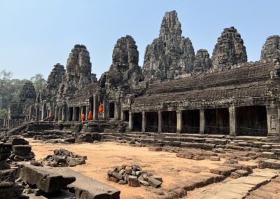 Monks in orange on steps of ancient temple