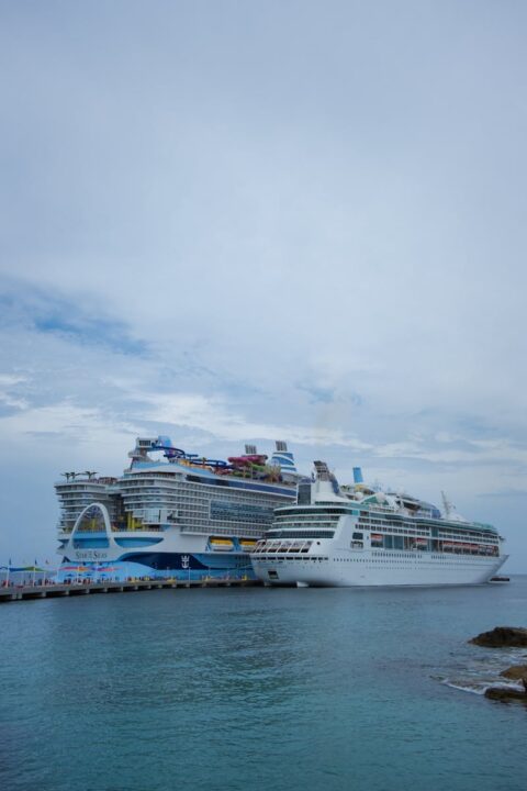 Two large cruise ships docked in the scenic Bahamas, showcasing luxury sea travel.