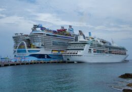 Two large cruise ships docked in the scenic Bahamas, showcasing luxury sea travel.