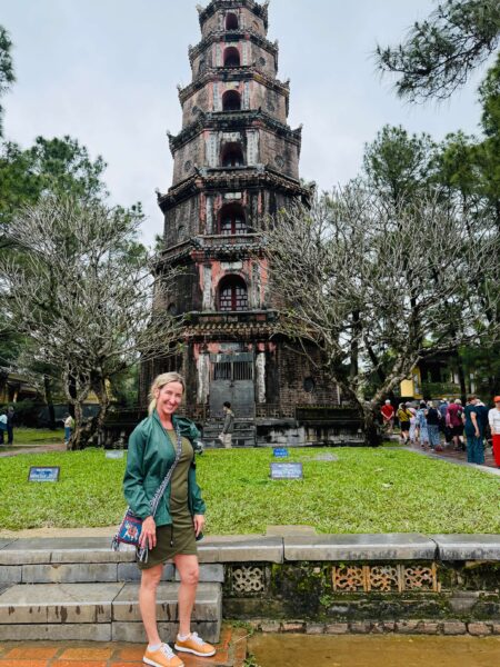 Hue Travel Guide: Imperial Vietnam, Tombs & Why It’s Worth a Stop 15 Traveler standing in front of the seven-story Phuoc Duyen Tower at Thien Mu Pagoda in Hue, Vietnam